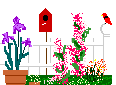 white garden fence with bird house and flowers